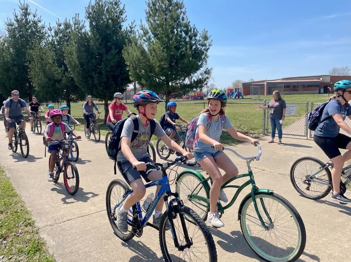 Happy children and parents biking together in a community bike train