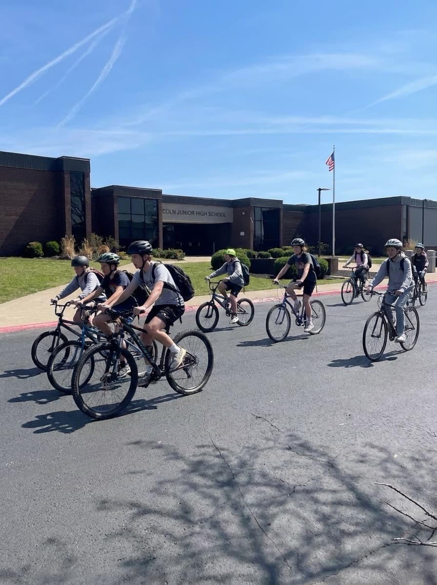 Group of teenagers riding bicycles together outdoors